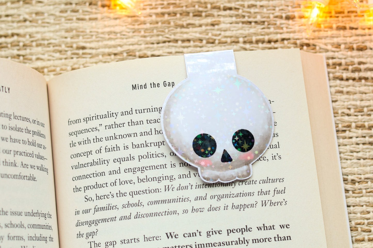 an open book with a skull brooch sitting on top of it