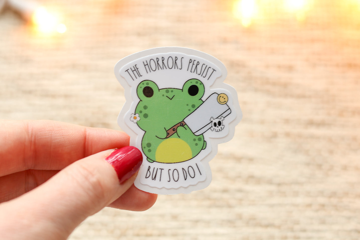 a person holding a sticker with a frog on it