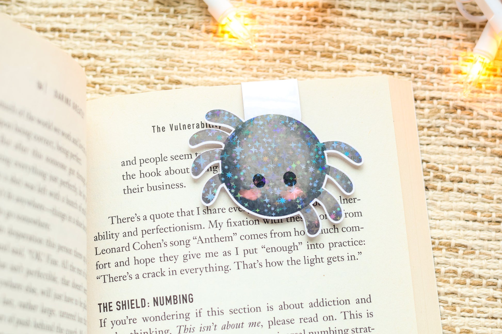 an open book with a crab brooch sitting on top of it