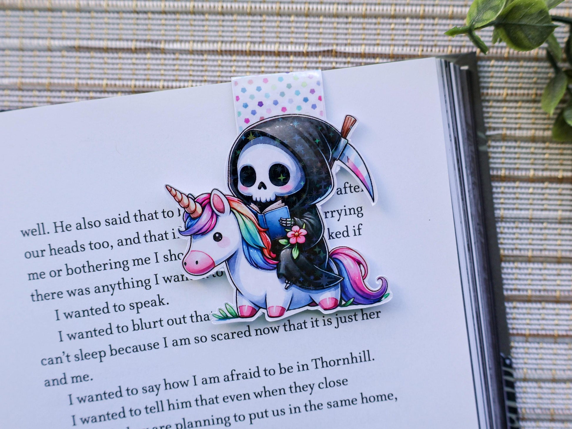 Holographic reaper skeleton reading a book on a unicorn with rainbow mane and tail